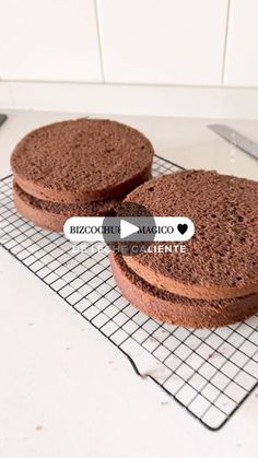 two chocolate cakes sitting on top of a cooling rack