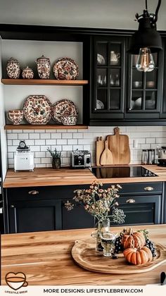 a kitchen with black cabinets and wooden counter tops