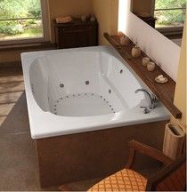 a large white bath tub sitting inside of a bathroom