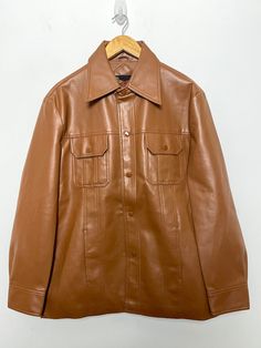 This jacket has some small marks on both sleeves and the back side. (please see photos for flaws) Measurements pit to pit: 23 inches  Top to bottom: 30 inches Brown Collared Leather Jacket With Snap Buttons, Retro Brown Outerwear With Snap Buttons, Vintage Leather Jacket With Snap Buttons, Retro Single Breasted Leather Jacket With Long Sleeves, Retro Single-breasted Leather Jacket With Long Sleeves, Retro Brown Outerwear With Button Closure, Vintage Leather Jacket With Button Closure, Vintage Button-up Leather Jacket With Pockets, Vintage Leather Jacket With Button-up Pockets