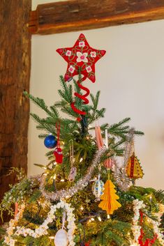 a decorated christmas tree with red and white stars on top, surrounded by other ornaments