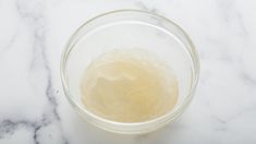 a glass bowl filled with liquid sitting on top of a marble counter