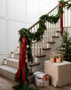 a staircase decorated with christmas garland and presents