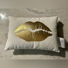 a white pillow with gold lips on it