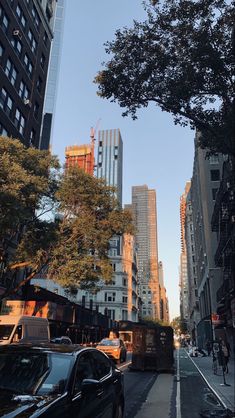 a city street with tall buildings and cars parked on the side of the road in front of them