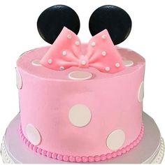 a pink and white cake with minnie mouse ears on top