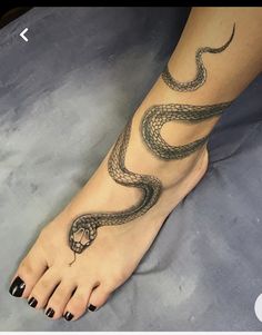 a woman's foot with a snake tattoo on it