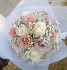 a bouquet of pink and white flowers sitting on top of a piece of paper