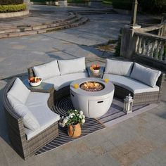 an outdoor fire pit surrounded by wicker furniture