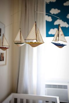 three small sailboats hanging from the ceiling