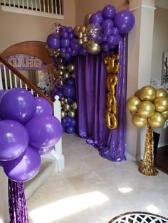 purple and gold balloons are on display in front of the stairs at a birthday party