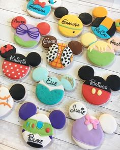 mickey mouse cookies are arranged on a white wooden table with the names of their characters