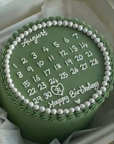 a green cake with white frosting and numbers on it