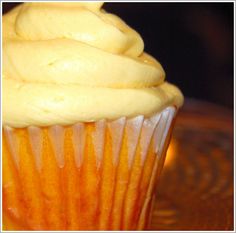 a cupcake with yellow frosting on a plate