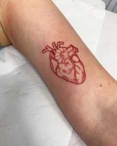 a small heart tattoo on the arm