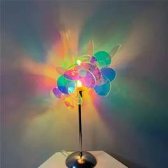 a multicolored lamp with a black base on a table