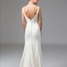 a woman in a white wedding dress looking back