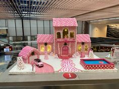 a pink and white castle cake on display at an airport