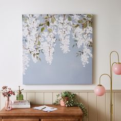 a painting hanging on the wall above a wooden table