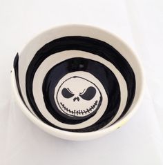 a black and white bowl with a jack skellingy face painted on the side