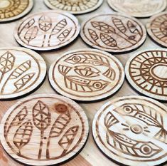 wooden buttons with designs on them sitting on a table