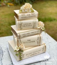 a stack of books sitting on top of a table next to each other with flowers