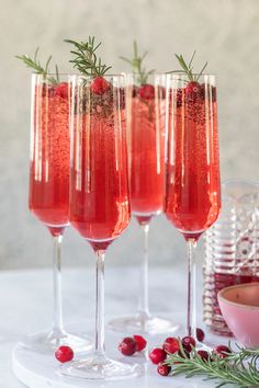 three wine glasses filled with cranberry spritz and garnished with rosemary