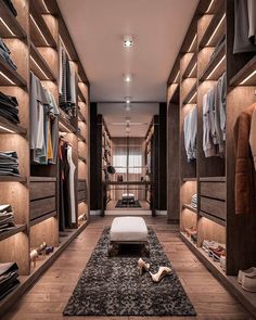 a walk in closet with wooden shelves and lighting