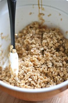 an oatmeal mixture in a white bowl with a black spoon inside it