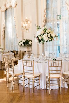 the tables are set with white and pink flowers