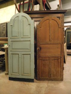 two wooden doors sitting next to each other on top of a floor in a room