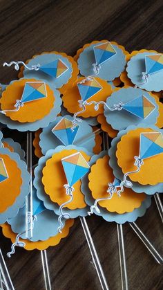 there are many cupcake toppers on the table with some paper kites in them