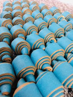 blue and gold striped cookies are stacked on top of each other in the shape of circles