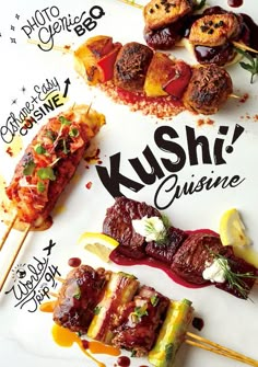 several skewers of food sitting on top of a white sign that says kushi cuisine