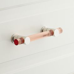 a close up of a white door handle with red and white knobs on it