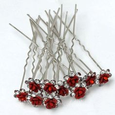 several red crystal hair pins on a white surface