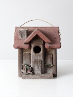 a wooden birdhouse with two birds in it