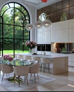 a dining room table surrounded by white chairs