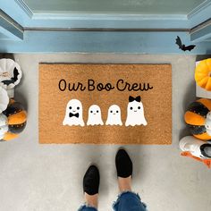 a door mat that says our boo crew with three ghost faces and bats on it