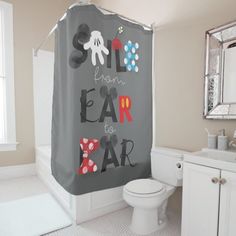 a bathroom with a shower curtain that has an octopus on it and the words smile from fear to air