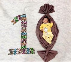 a baby laying on top of a blanket next to the letter e and beaded letters