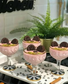 four desserts are sitting in glasses on a tray