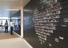 two men standing in front of a wall with pictures on it