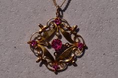 The 185th Street: Antique Seed Pearl and Vivid Pink Doublet Necklace. The pendant showcases a vibrant pink doublet at its center, accented by seed pearls positioned in the cardinal directions. Below, a polished section is followed by delicately scrolled filigree adorned with a floral motif. The pendant is further embellished by four additional vivid pink doublets. It is exquisitely crafted in yellow gold and features serial numbers on the reverse side for authenticity. The pendant elegantly hang Cardinal Directions, Recycled Gifts, Seed Pearl, Three Stone Rings, Fine Jewellery Necklace, Gold Bangles, Floral Motif, Stone Rings, Necklace Etsy