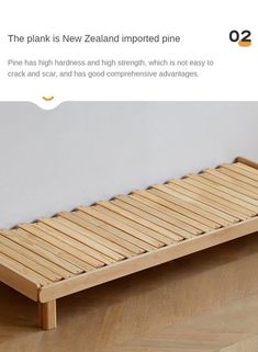 a bed frame made out of wood with no sheets on it, sitting on the floor