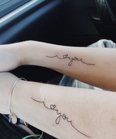 two people sitting in a car with tattoos on their arms that say you and love