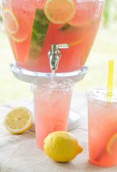 two glasses filled with water and lemons next to each other on a table outside