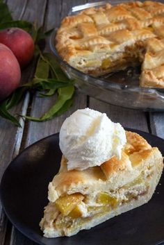 a piece of pie with ice cream on top and some peaches in the background