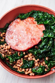 a bowl filled with spinach, beans and meat