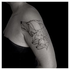 a black and white photo of a woman's arm with a tattoo on it